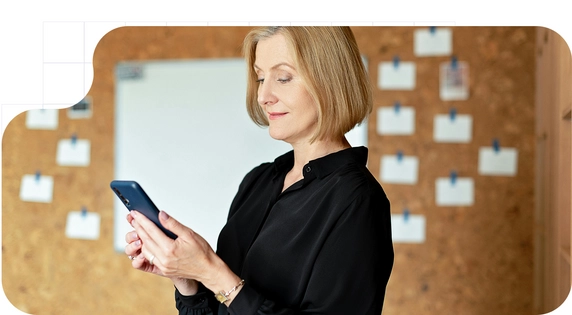 Mujer utilizando un teléfono móvil en un entorno profesional, consultando información digital. Mujer usando un teléfono móvil en un entorno profesional, consultando información digital.