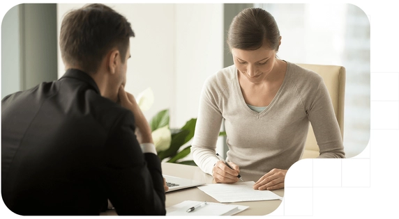 Woman signing a document related to a qualified electronic signature at an office desk.